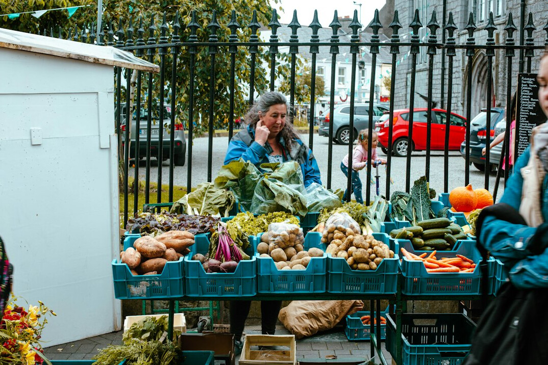 South Asian-Canadian woman examining fresh produce at an outdoor farmers market