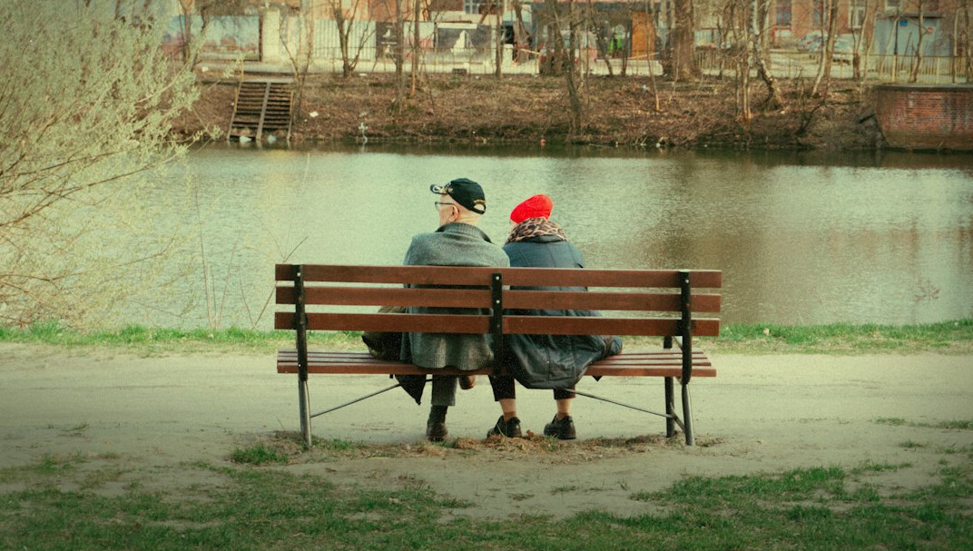 Elderly East Asian-Canadian couple sitting together on a park bench